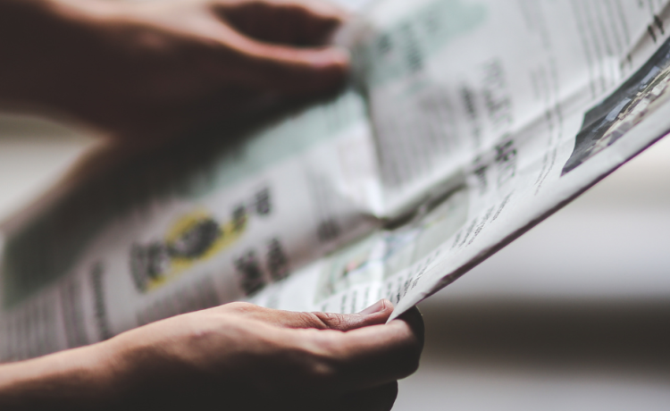 Person sucht in der Zeitung nach Jobs